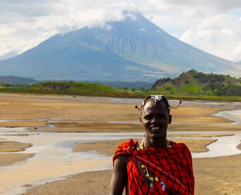 A Maasai with traditional clothing in the Lake Natron area with Ol Doinyo Lengai mountain in the background