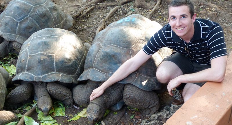One of our guests posing with a giant turtle on Prison Island